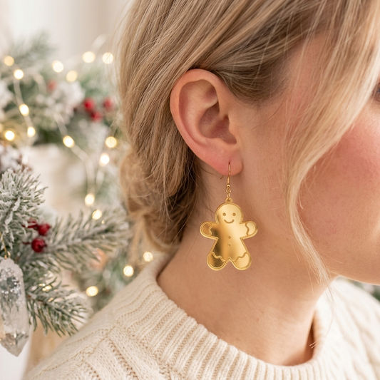 Chica utilizando aretes navideños en forma de galleta de muñeco de jengibre en un fondo festivo.