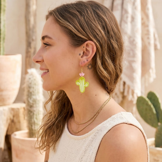 Modelo utilizando aretes en forma de cactus cortados a laser en acrilico verde y rosa