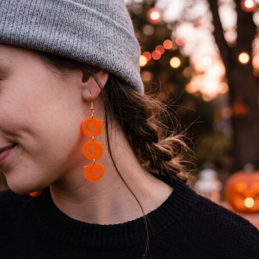 Modelo utilizando aretes de calabaza de acrilico naranja cortados a laser