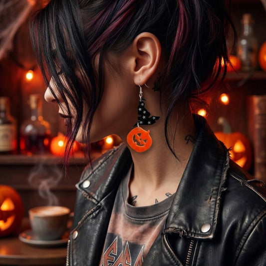Modelo usando aretes en corte laser de acrilico naranja en forma de calabaza y acrilico negro en forma de sombrero de bruja