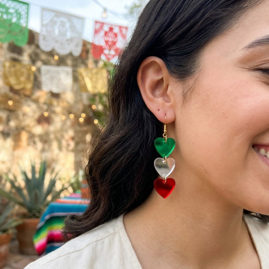Modelo usando aretes cortados a laser de acrilico espejo verde, plata y rojo en forma de corazon, fiestas patrias. Viva mexico