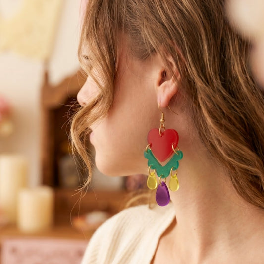 Modelo usando aretes de milagritos mexicanos cortados a laser en acrilico cristal verde, rojo, morado y amarillo