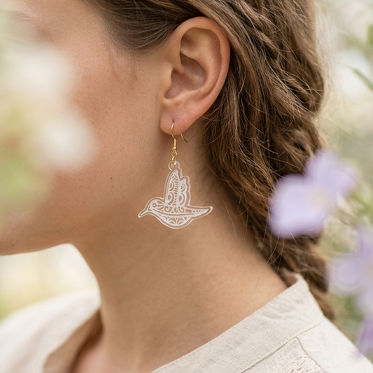 Modelo utilizando aretes de acrilico grabados a laser de colibri