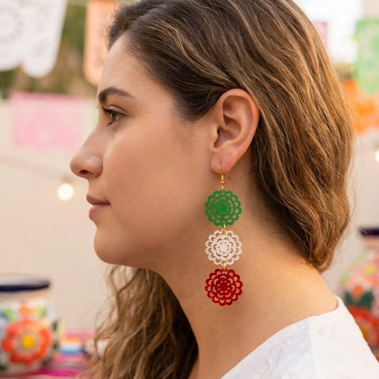 Modelo utilizando aretes de acrilico en forma de flor cortados a laser en acrilico verde cristal y rojo viva mexico