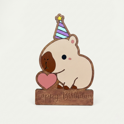 ajas dulceras personalizadas con figura de capibara, gorro de fiesta y grabado Cappy Birthday. Hechas a mano en madera MDF con nombre en acrílico para centros de mesa o recuerdos reutilizables de cumpleaños.