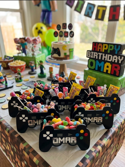 Ejemplo de 8 Cajas dulceras personalizadas con forma de control de videojuegos hechas en madera MDF calada a láser y pintadas a mano. Ideal para fiestas temáticas de gamers, centros de mesa y lapiceros de escritorio de niños.