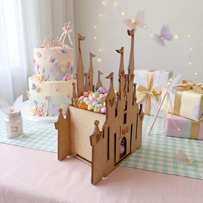 Ejemplo de producto puesto en una mesa de dulces. Castillos dulceros de madera MDF estilo Disney personalizables con nombre grabado y edad. Kit para armar y pintar en casa, perfecto como centro de mesa para fiestas infantiles o recuerdo de cumpleaños original.